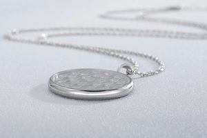 Detailed view of silver stainless steel round pendant with sunshower engraved text