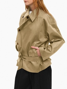 Detail of khaki short trench coat featuring double-breasted buttons and waist belt