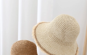 Detalle de sombreros de paja con bordes deshilachados y textura tejida de alta calidad