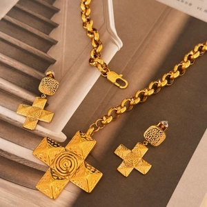 Detail of 18k gold plated cross pendant necklace and earrings with hammered texture