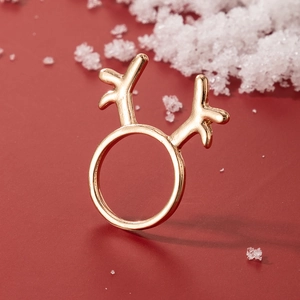 Close-up of golden reindeer antler ring on festive red background with snowflakes