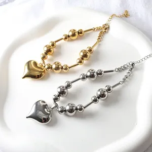 Polished 18k gold and silver steel bead bracelets with large heart pendants in a set