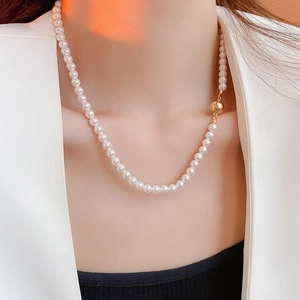 Détail du collier de perles élégant avec fermoir sphérique doré sur un mannequin