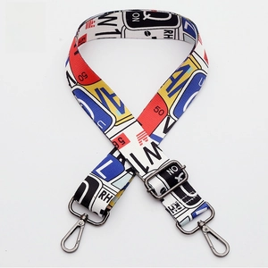 Detail of adjustable woven purse strap with colorful graffiti print and gunmetal hardware
