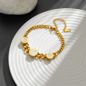 Detailed view of a gold-plated Cuban chain bracelet with white shell Roman numerals