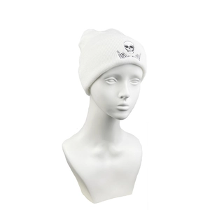 Front view of white knitted beanie featuring black skull and bone hand graphic print