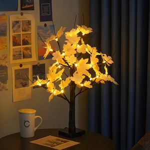 Detail of warm LED maple leaf tree light with realistic trunk for cozy home decor