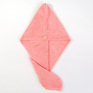 Detailed close-up of pink coral fleece hair towel with a cute bear button closure