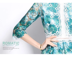 Détails de la broderie florale en dentelle ajourée vert émeraude et blanc de la robe