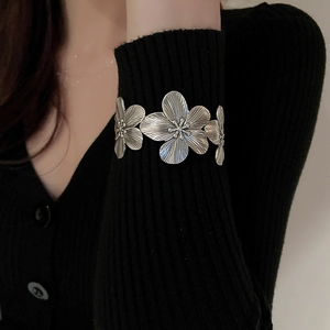 Close-up of vintage silver floral cuff bracelet with detailed textured flower petals