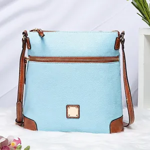 Close-up of light blue lychee pattern leather handbag with brown straps and gold buckle