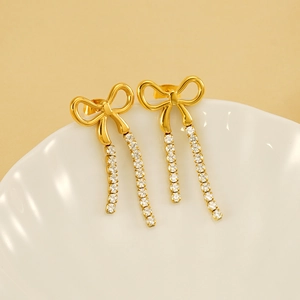 Elegant gold bow earrings with long sparkling diamond-encrusted tassel chains