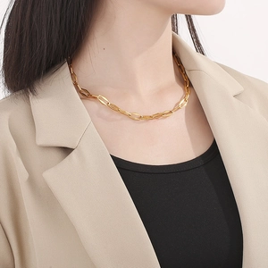 Dettaglio della collana in acciaio al titanio dorato con chiusura OT indossata da modella