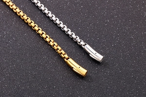 Detail showing high-quality gold and silver box chain links with a cylindrical clasp