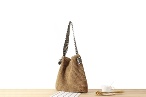 Detail of the paper rope weave texture and striped knotted strap on the shoulder bag