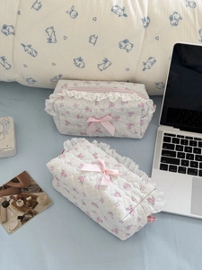 Floral quilted cosmetic bag set with pink roses lace trim and ribbon bow on bed