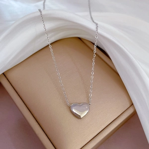 Collier avec pendentif cœur argenté sur soie dans un coffret à bijoux champagne