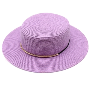 Dettaglio cappello di paglia lavanda a tesa piatta con elegante nastro metallico oro