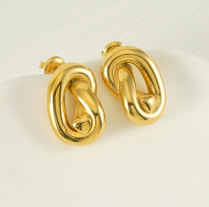 Vue macro de boucles d'oreilles ovales plaquées or 18K avec détail cœur embossé