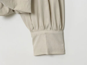 Nahaufnahme der plissierten Manschette einer beigen Freizeitjacke mit hohem Kragen für Damen