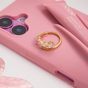 Close-up of a gold-plated adjustable ring with brilliant white zircon stones in pink setting