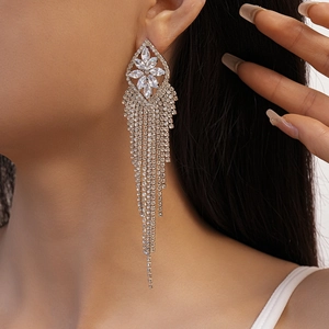Detail of luxury rhinestone flower tassel earrings hanging elegantly on a model