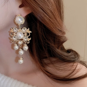 Close-up of vintage baroque pearl tassel earrings with rhinestones on a female model