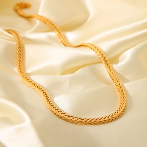 Elegant 18K gold plated braided titanium steel necklace on soft cream silk fabric