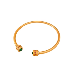 Bracelet vintage plaqué or 18k avec pierres précieuses rouges et vertes sur fond blanc