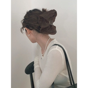 Minimalist large brown fabric hair claw clip shown on a model in a Korean style