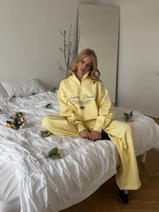 Women's yellow tracksuit with zip sweatshirt and wide-leg joggers in cozy home setting