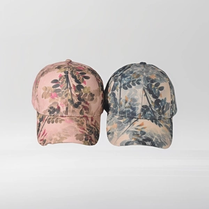 Detail of classic curved brim baseball caps with vibrant botanical leaf prints in pastel tones