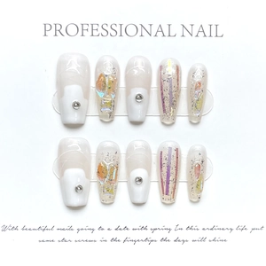 Macro detail of handmade press-on nails with white base, silver studs and aurora flakes