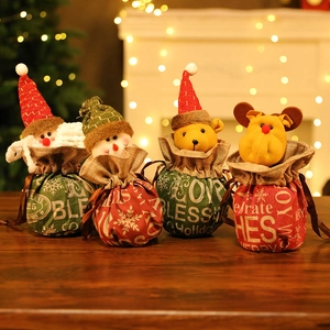 Christmas burlap gift bags set with plush Santa and Snowman figures in cozy festive setting