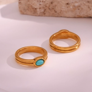 Detail of 18K gold plated stainless steel rings with a smooth band and oval turquoise stone