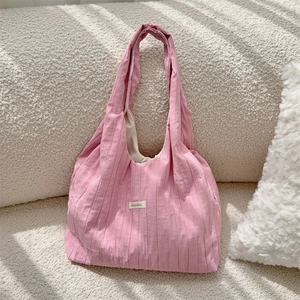 Detail of pink pleated fabric texture on a minimalist shoulder bag with Sozakka tag