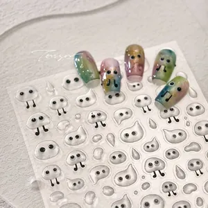 Macro detail of cute ghost nail stickers with gold stamping and rainbow gradient finish