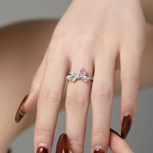 Detail eines S925 Silberrings mit Schleife und rosa herzförmigem Hauptstein im Fokus