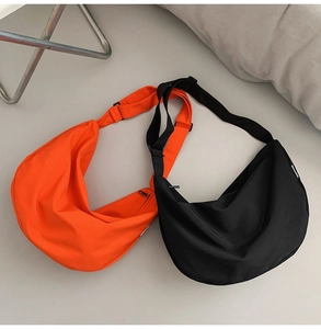Detail of waterproof nylon crescent bags in orange and black with adjustable straps