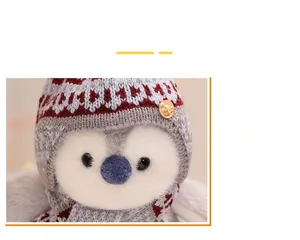 Close-up of plush penguin with knitted hat, scarf and decorative gold buckle detail