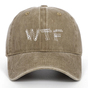Close-up of white WTF embroidery on a vintage washed khaki cotton baseball cap