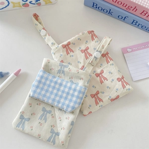 Floral fabric nurse pocket protector with snap button and blue bow detail closeup