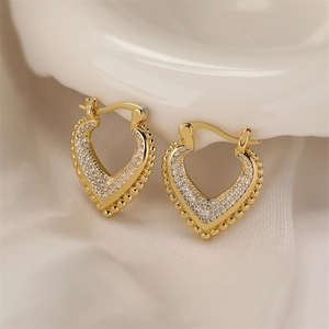 Macro shot of gold-plated heart earrings with micro-inlaid white zircons and bead edges