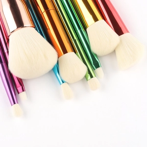 9-piece makeup brush set with vibrant rainbow gradient handles and white synthetic bristles