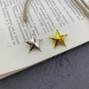 Golden and silver 3D star cake toppers on a vintage book page for Christmas decor