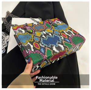 Detail of snake skin pattern texture and dark metal chain on colorful square bag