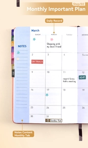 Close-up of blue monthly planner pages with index tabs and writing notes
