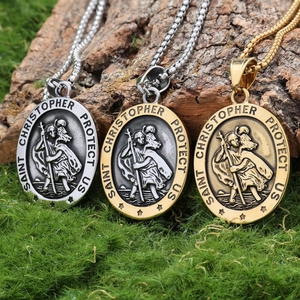 Three Saint Christopher necklaces in silver and gold on natural wood with moss