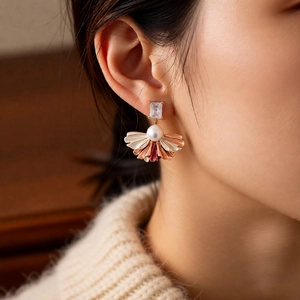 Détails de boucles d'oreilles vintage avec perles et zircon portées par un mannequin