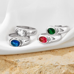 Detailed view of silver rings featuring colorful cubic zirconia on silk and natural stone